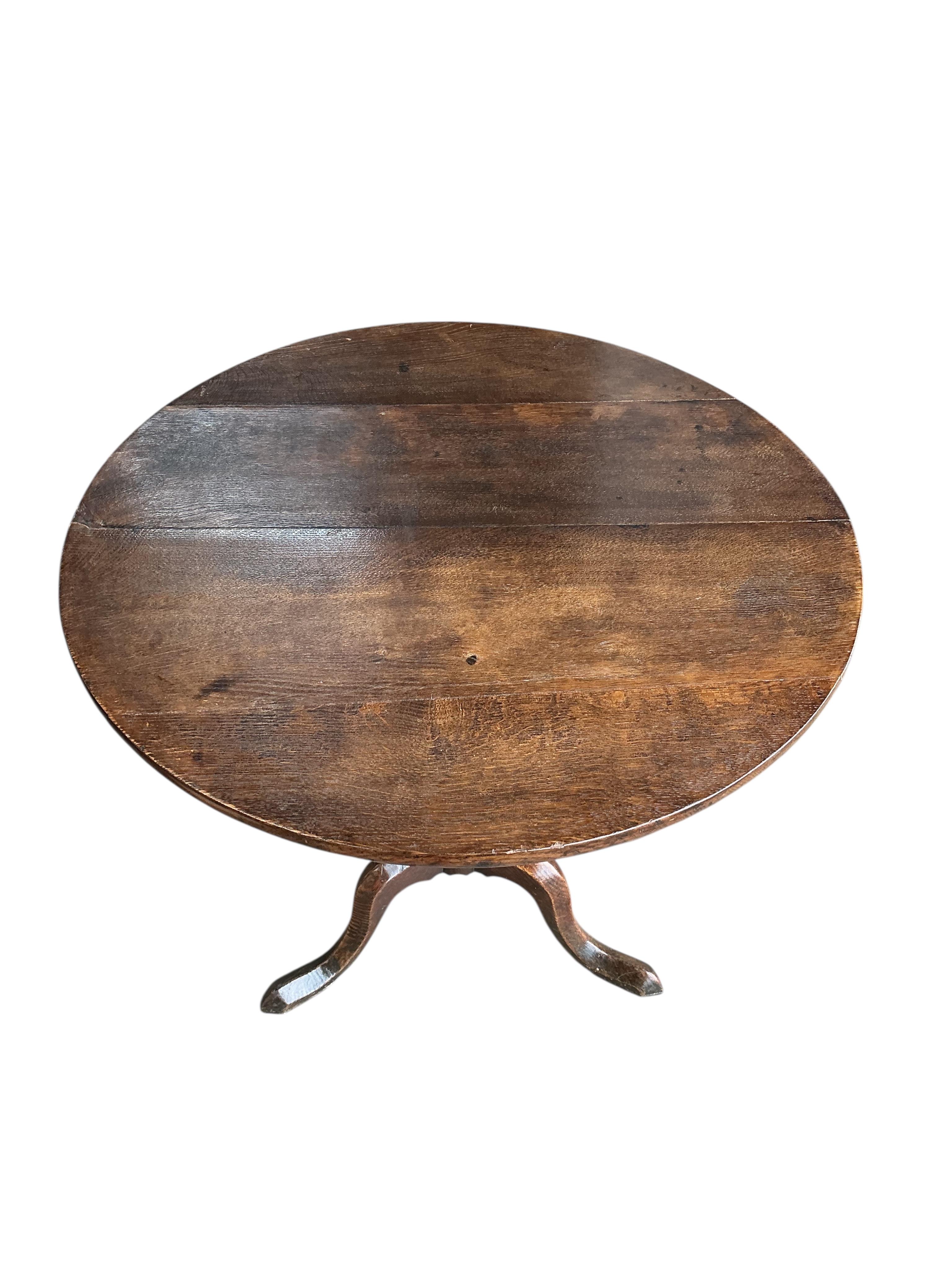 An early 19th century circular oak tilt top tripod tea table, diameter 76cm, height 72cm